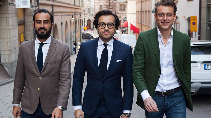 Three people walking down street 