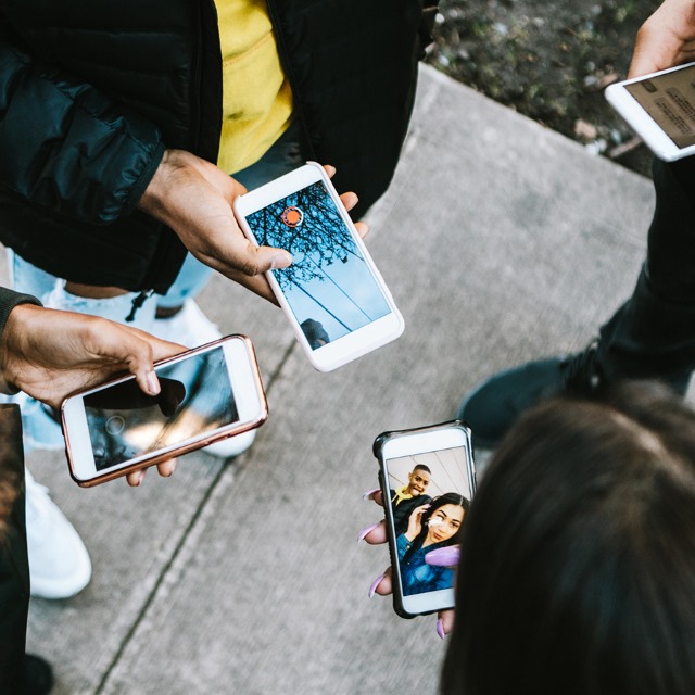 people standing in a circle on phones